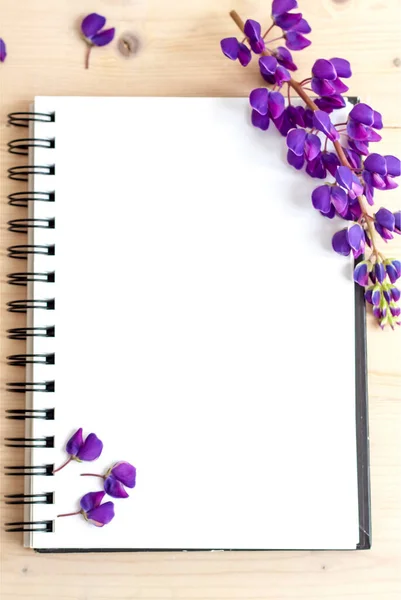 Beautiful purple flowers on a Notepad for writing. Background for presentation and design of graphic works.