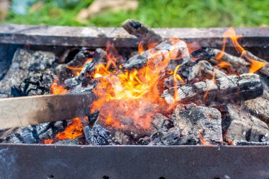 Pişirme makinesinde kızgın kömür ve alevler. Kömürlü ızgara. Ateş ve sıcaklık.