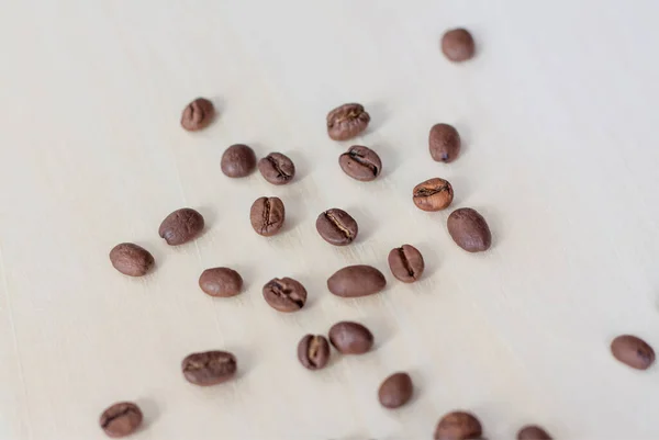 Roasted coffee beans on a wooden background. Coffee and light wood background. Seeds.