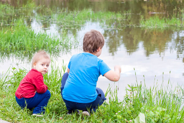 Children. Watch the animals squatting by the lake. Boys at the pond.