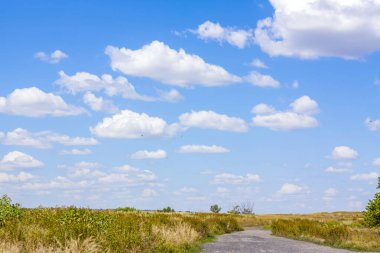 Kırsal kesimde bir yol. Güzel gökyüzü ve yolu olan manzara.