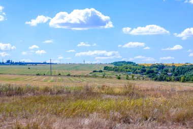Güzel gökyüzü ve tarlası olan kırsal alan. Beyaz bulutlu mavi gökyüzü.