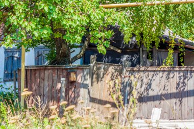 Eski ve neredeyse çökmüş bir çit. Bozuk çitli terk edilmiş bir ev..