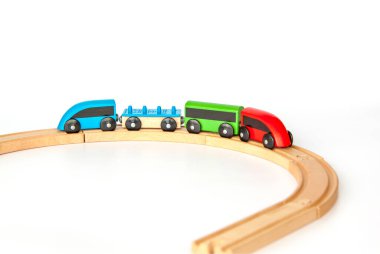 Beyaz arka planda tahtadan yapılmış çocuk demiryolu. Tahta renkli karavanlar. Tahtadan yapılmış çocuklar için oyuncaklar. 