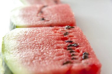 Beyaz arka planda dilimlenmiş kırmızı karpuz. Yüzeyde karpuz dilimleri var. Beyaz arkaplan.