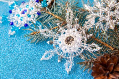 Mavi, parlak bir arka planda Noel unsurlarının yerleşimi. Ladin dalı, koniler ve kristal kar taneleri. Ladin dalı ve çam kozalakları. Mutlu bir Noel 'e hazırlanıyorum