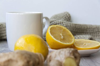Limonlu zencefil çayı. Soğuk algınlığı ve enfeksiyon mevsimi. Bağışıklığın güçlenmesi. Sıcak bir eşarpla limonlu ve zencefilli bir fincan çay..