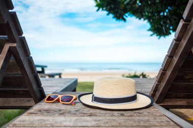 Yaz arka plan güzel plaj var deniz ve mavi gökyüzü yakınındaki ahşap masa üzerinde güneş şapka yer