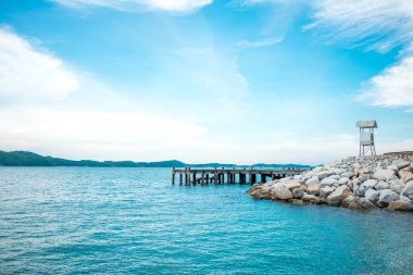 sahne manzaralı güzel sahil şeridi deniz ve mavi gökyüzü arka plan üzerinde ahşap köprü var