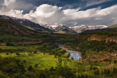 Dağların ve yeşil ağaçların arka planında güzel bulutlar. Dağlık arazinin dağ manzarası.