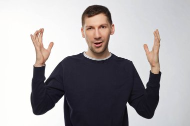 Kapalı stüdyo sürpriz erkek işçi balık yakaladı boyutunu gösteren vurdu. Bir şey büyük ya da çok büyük elleri ile boyutunu gösteren yakışıklı güçlü erkek. Şaşırmış gibi erkek beyaz duvardan el hareketi.