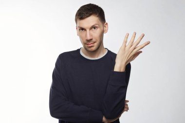 Ne yani, kimin umurunda. Belirsizlik, jesti sorgulama içinde omuz shrugging rahat, giyinmiş emin şüpheli esmer adam, kadar clueless bak, beyaz stüdyo duvarda izole karışık kaş yükseltir