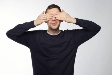 Mutlu bir adam kız arkadaşı veya karısı, ayakta ve sürpriz için beklentisiyle gülümseyen tarafından hazırlanan sürpriz görecek elleriyle gözlerini kapatma. Neşeli yakışıklı oynayan baby ile saklambaç.