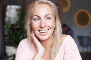 Kadın portre sarışın mutlu gülümseyerek, geniş bir gülümseme ile yakından ifade mutluluk vardır, kafe iç, iyi ruh hali içinde olmak karşı aittir, zor iş günü sonra mola vardır. Olumlu duygular kavramı.