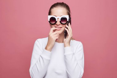 Endişeli baştan çıkarıcı kadın modeli ihale gülümseme ile parmak ısırır, modern akıllı telefon siyah durumda tutar, ödeme başarısızlık olduğu gibi sinirli hissediyor. Güzel bayan sormak kocam ayakkabı satın almak.