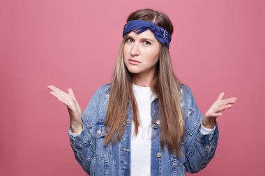 Bu ne demek? Kızgın şaşkın çekici genç kadın hareketleri el ile sürekli yanlış anlama, tatminsizlik, pembe bir arka plan üzerinde izole frowns karşısında olduğu gibi açıldı gözleri kocaman.