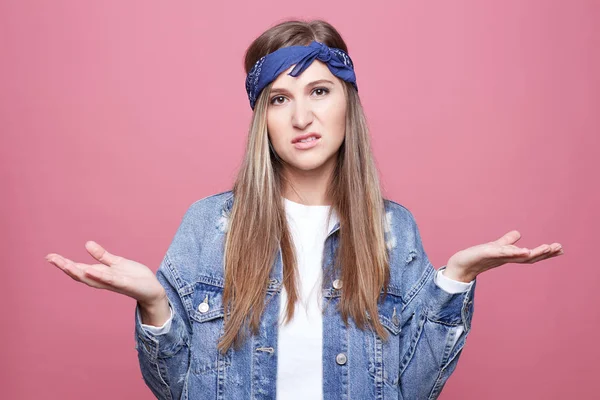 Şikayetçi ifade, frowns yüz, ile mutsuz sarışın Avrupa kadın iki elle, el hareketi pembe arka plan üzerinde duruyor. Hayal kırıklığına uğramış genç kahverengi gözlü kadın kot ceket soru vardır.