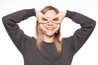 Gözler, el ele tutuşarak komik ve yaratıcı genç kız öğrenci portresi gözlük jest geniş içten gülümseme ile beyaz arka plan üzerinde gösterir. Döküm taklit pilot sunan yeni doğumlu oyuncu.