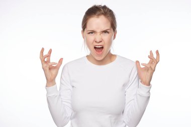 My voice matters. Portrait of displeased outraged pretty blond tender lady, raising clenched fists, bending towards camera and shouting, fighting with troubles and being pissed off over white wall.