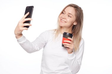 Mükemmel ışık alma portre için. Atış şık güzel kadının uzun saçlı beyaz, kahve alarak selfie, geniş ekran keyfi yerinde olmak, gülümseyen süre tutarak izole kapatmak.