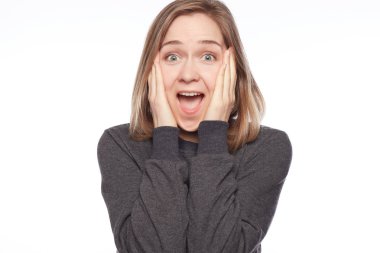 Yakından atış hayran güzel sarışın kadın söyler ve aktif, jestleri ona büyük sürpriz ifade eder, beyaz stüdyo kopya alanı üzerinde izole sıradan gri kazak giyer, bağırır: Wow, bu harika.!