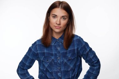 Kendine güvenen bakışla çekici karışık yarış kartlarının genç olan kahverengi düz saç, kayıtsızca giyinmiş, hafifçe gülümsüyor, doğrudan kameraya, gelmek, sevgilisi için bekliyor standları görünüyor beyaz beton duvara.