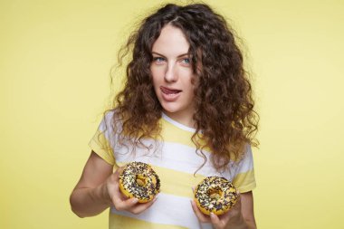  Stüdyo çöl yeni meme olarak çalışan plastik cerrahi hakkında rüya çörek ile oynarken mutlu genç kıvırcık saçlı güzel Amerikalı kadın, bir kadeh. İnsanlar, gıda, beslenme, beslenme ve sağlıksız yaşam tarzı.