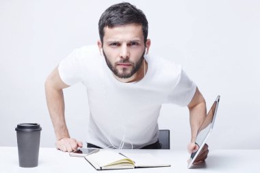 Hey, dinle beni! Ne dedin? Hile, endişeli ifade şüpheli ortağı ile ciddi vahşi erkek çekiyor gadget'lar beyaz ofis arka planda çevrili birinin dikkatine.
