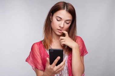 Tırnak ısırma cep telefonunuzun ileti alma şok haber veya sosyal ağlar üzerinden tarama newsfeed okurken bak, şaşkın dalgın esmer kadın. Yüz ifadesi, reaksiyon kavramı