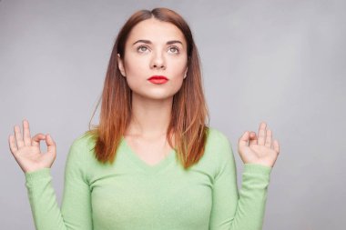 İyi şanslar, geçen sınav, gri stüdyo duvarda izole rahat yeşil gömlek giymiş korktuğum bir şey ile şaşkın için parmakları dehşete koyu saçlı Genç yatay atış haçlar.