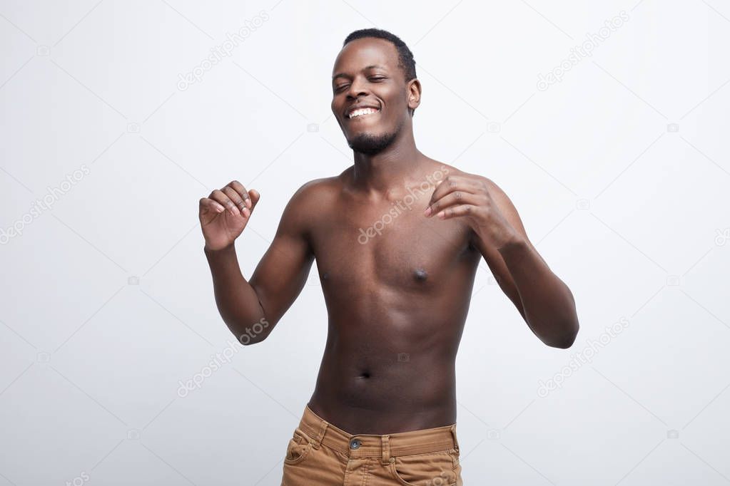 B yourself, enjoy who you are, taste life, feel the moment, dance, create, love, live the life. Human being concept. Cheerful happy African American guy dancing, listening to favorite music on white.