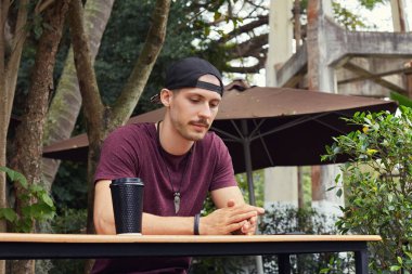 Dalgın öğrenci hayatı hakkında düşünme, seyir tek kullanımlık siyah şık fincandan kahve içme moda elbise, moda aksesuarları kafede, tek başına oturan giymiş arkadaş, bekliyor. 