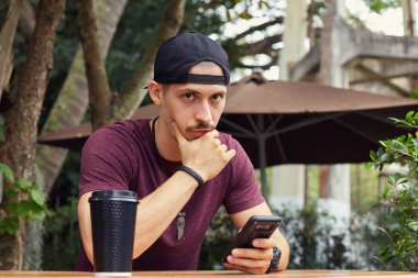 Yatay mesafe, bakan dalgın karışık yarış adam telefon, tutarak portresi bazı sorunlar var, çok hızlı bir şekilde çözmek çalışır. Beyaz genç şık hipster kötülerden hayat hakkında molası sırasında.