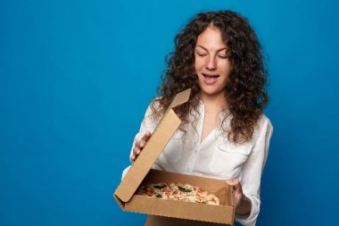 Aç kadın lezzetli pizzalar yerken ağzını kocaman açar, yemek yemek ister, beyaz gömlek giyer, mavi stüdyo duvarına karşı mankenler. Pozitif kadın karantinaya bağlı olarak eve teslim ediliyor. İnsanlar ve yiyecekler.