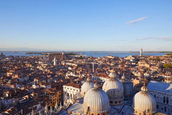 Elevated view of Venice with basilica domes and rooftops from San Marco bell tower before sunset, Italy