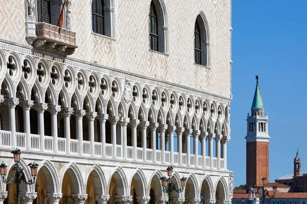 Venice, Doge palace facade and San Giorgio Maggiore bell tower in a sunny day in Italy