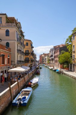 Venice, İtalya - 14 Ağustos 2017: Canal bir güneşli yaz günü Venedik'te insanlarla İtalyan restoran ve kaldırım tablolarla