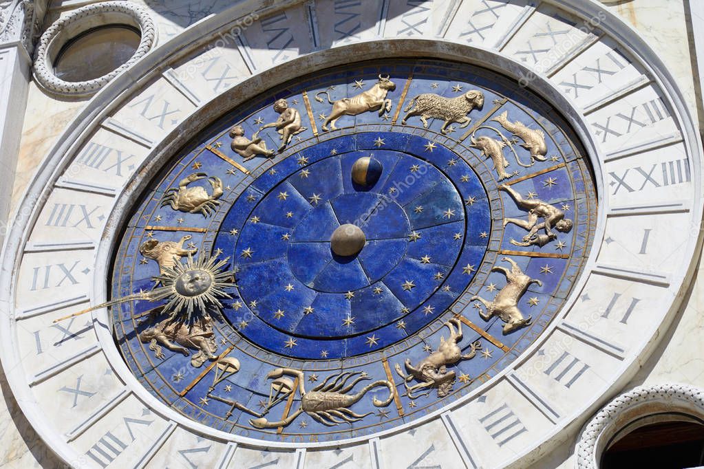 Astrological clock with gold zodiac signs in a sunny day