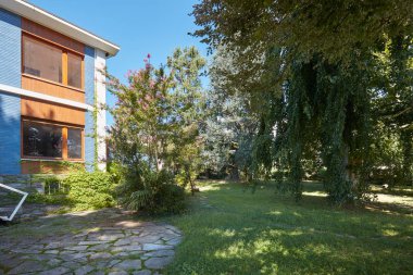 Villa ile büyük pencereler ve bir güneşli yaz günü bahçede açık mavi gökyüzü