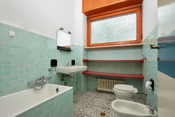 Old bathroom with bathtub and bidet in apartment interior