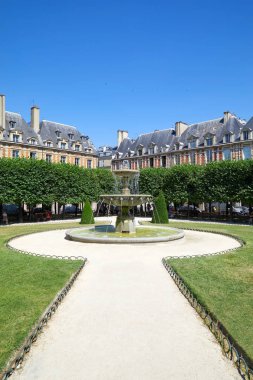 Place des Vosges, yolu bir güneşli yaz günü Paris'te bahçesinde çeşme ile açık mavi gökyüzü 