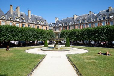 Paris, Fransa - 6 Temmuz 2018: Place des Vosges bir güneşli yaz günde çimenlerde güneşlenme insanlarla açık mavi gökyüzü Paris