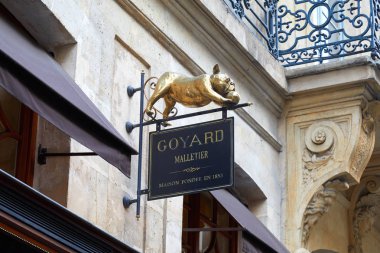 Paris, Fransa - 07 Temmuz 2018: Goyard lüks mağaza Paris'te, antik siyah işareti ile altın Fransız buldozer heykel.