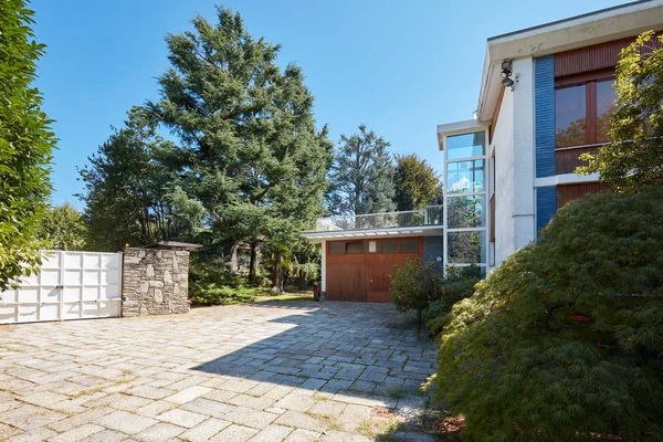 别墅与花园 白色的大门和车库在一个阳光明媚的夏日 晴朗的蓝天 — 图库照片
