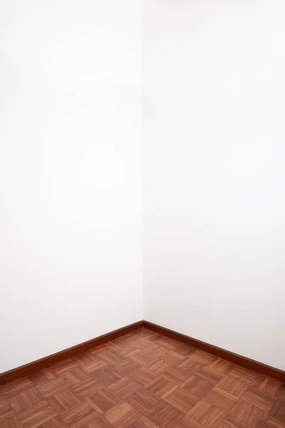 带棕色木制瓷砖地板和白色空白墙的房间角落 — 图库照片