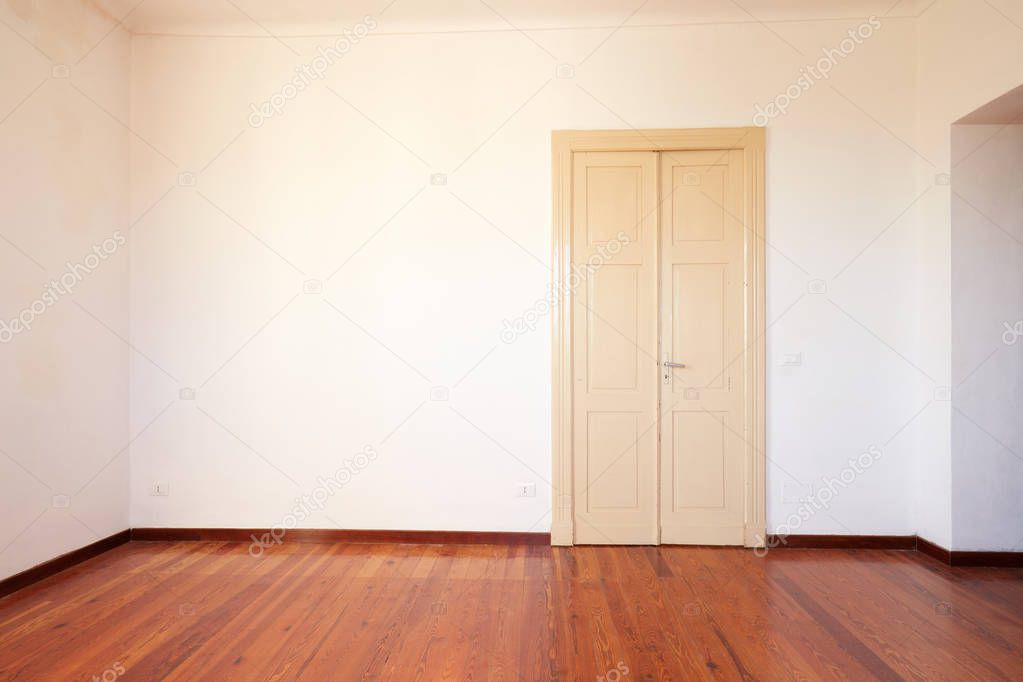Empty room with wooden floor and door in old house