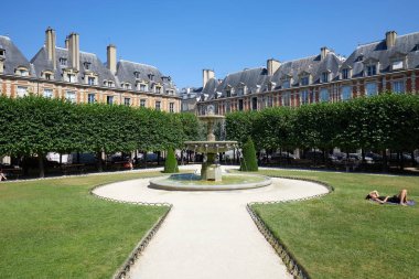 Paris, Fransa - 6 Temmuz 2018: Place des Vosges çim ve bir güneşli yaz günü tezgah üzerinde kişi ile Paris'te mavi gökyüzü temizleyin