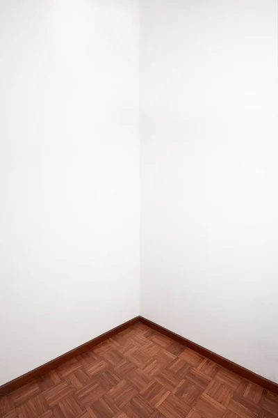 带棕色木制瓷砖地板和白色空白墙的空房间角落 — 图库照片