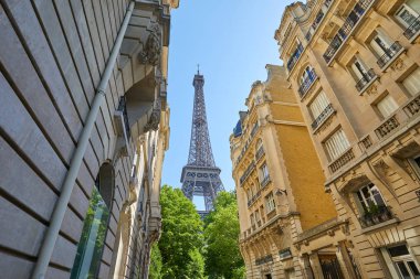 Paris, Fransa - 21 Temmuz 2017: Eyfel Kulesi ve tipik sokak eski binalarda bir güneşli yaz günü Paris'te olan açık mavi gökyüzü