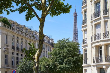 Paris, Fransa - 21 Temmuz 2017: Eyfel Kulesi, Paris binalar ve ağaçlar içinde güneşli yaz gün, açık mavi gökyüzü